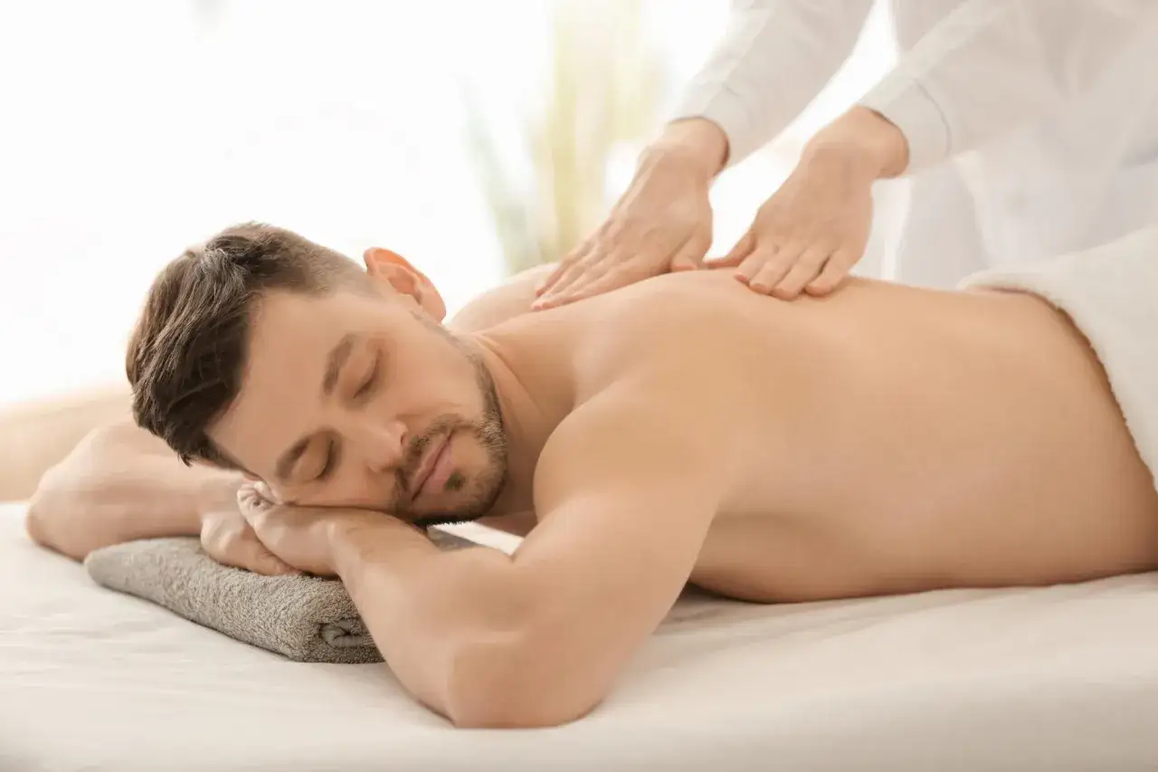 Relaks w spa w Kazimierzu Dolnym. Mężczyzna leży na masażu pleców, zrelaksowany, z zamkniętymi oczami.