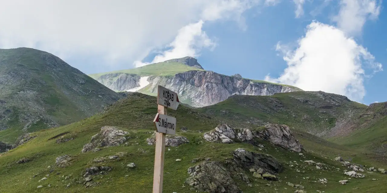 Droga na szczyt Korab 2764m. Wskazówka kieruje na górę, a pod nią tabliczka z napisem S. Mavrovo.