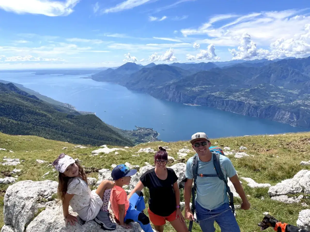 Rodzina z psem cieszy się widokiem na jezioro Garda z Monte Baldo.