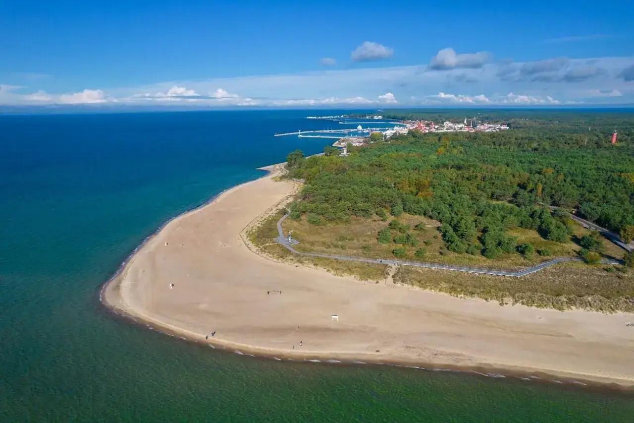 Piękne miasta nad morzem, z piaszczystą plażą i zielonym lasem, wpadają w turkusowe wody Bałtyku.