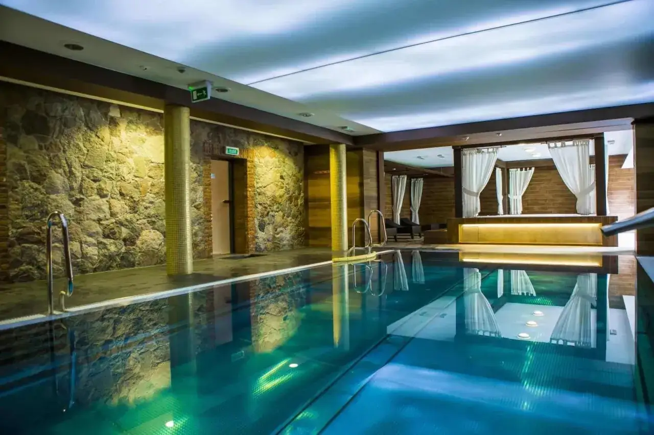 Basen w hotelu spa Kaszuby. Kamienne ściany, turkusowa woda i zaciszne miejsca do relaksu tworzą atmosferę luksusu.
