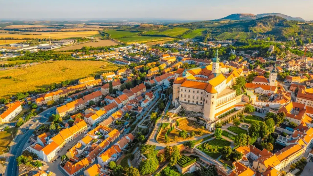 Malownicze miasteczko w Czechach, idealne na wakacje. Zamek na wzgórzu góruje nad kolorowymi dachami i zielonymi wzgórzami.