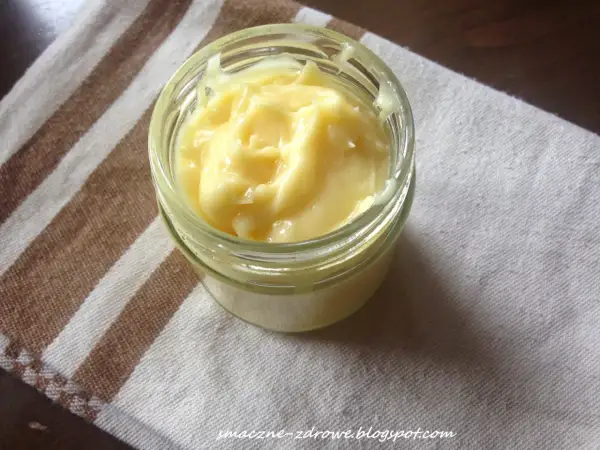 Domowy aioli w słoiczku, kremowy i puszysty, gotowy do podania z ulubionymi potrawami.