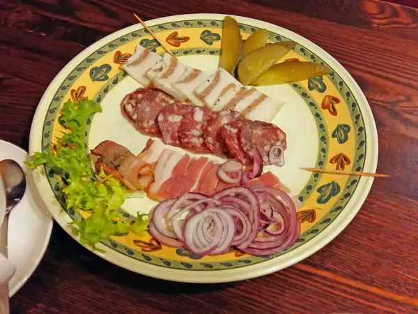 Talerz z wędlinami, słoniną, ogórkami i cebulą. Idealne danie, by dowiedzieć się, co zjeść w Wilnie.