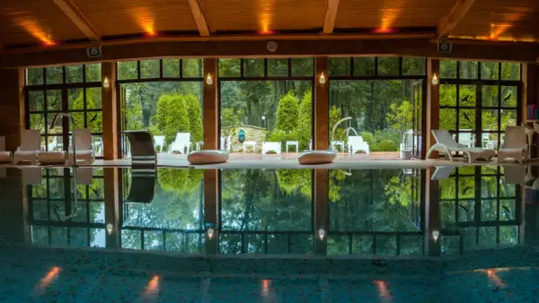 Relaks w hotelu spa lubelskie. Basen z leżakami i widokiem na ogród.